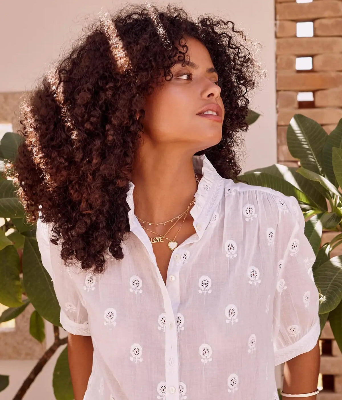 Model wearing the M.A.B.E Frani Embroidered Short Sleeve Top in White, styled with layered gold necklaces