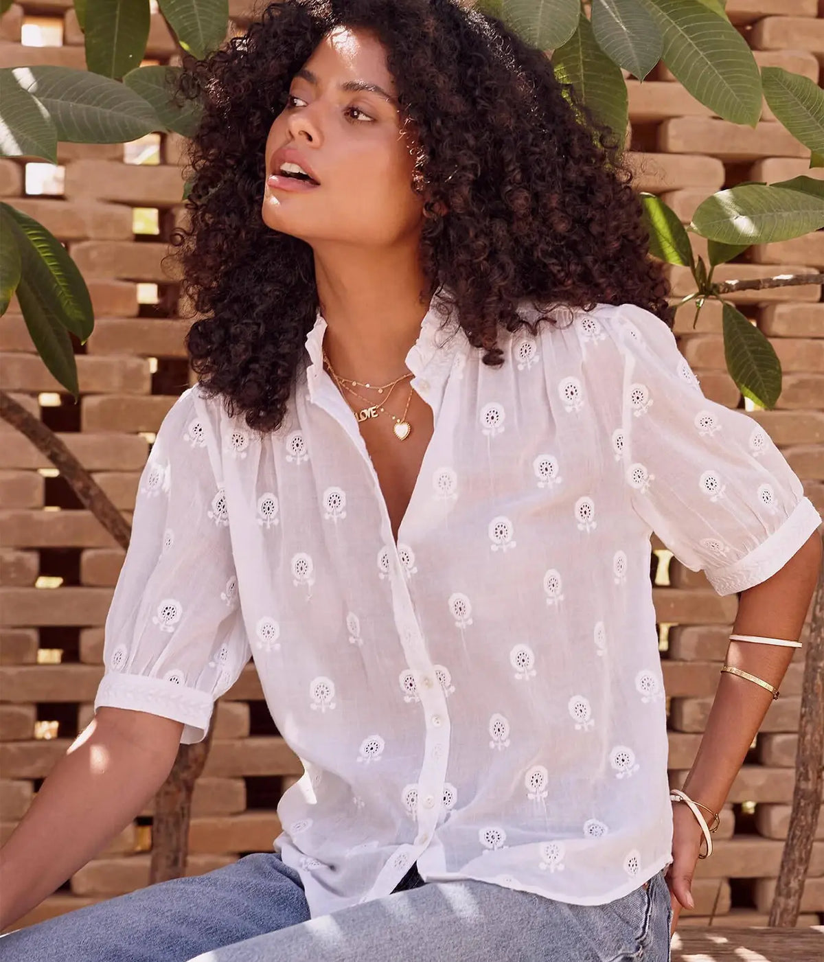Model wearing the M.A.B.E Frani Embroidered Short Sleeve Top in White with light blue jeans