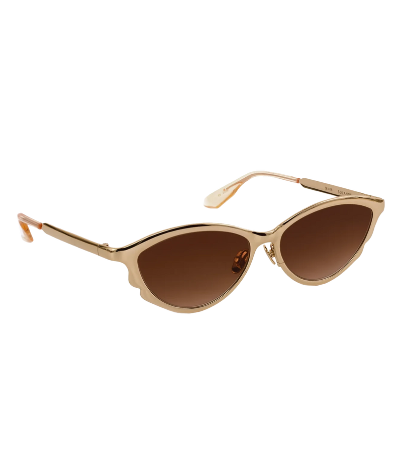 Three-quarter view of the KREWE Solange Sunglasses in 18K Chroma Champagne, showing the slim gold temples and elongated silhouette