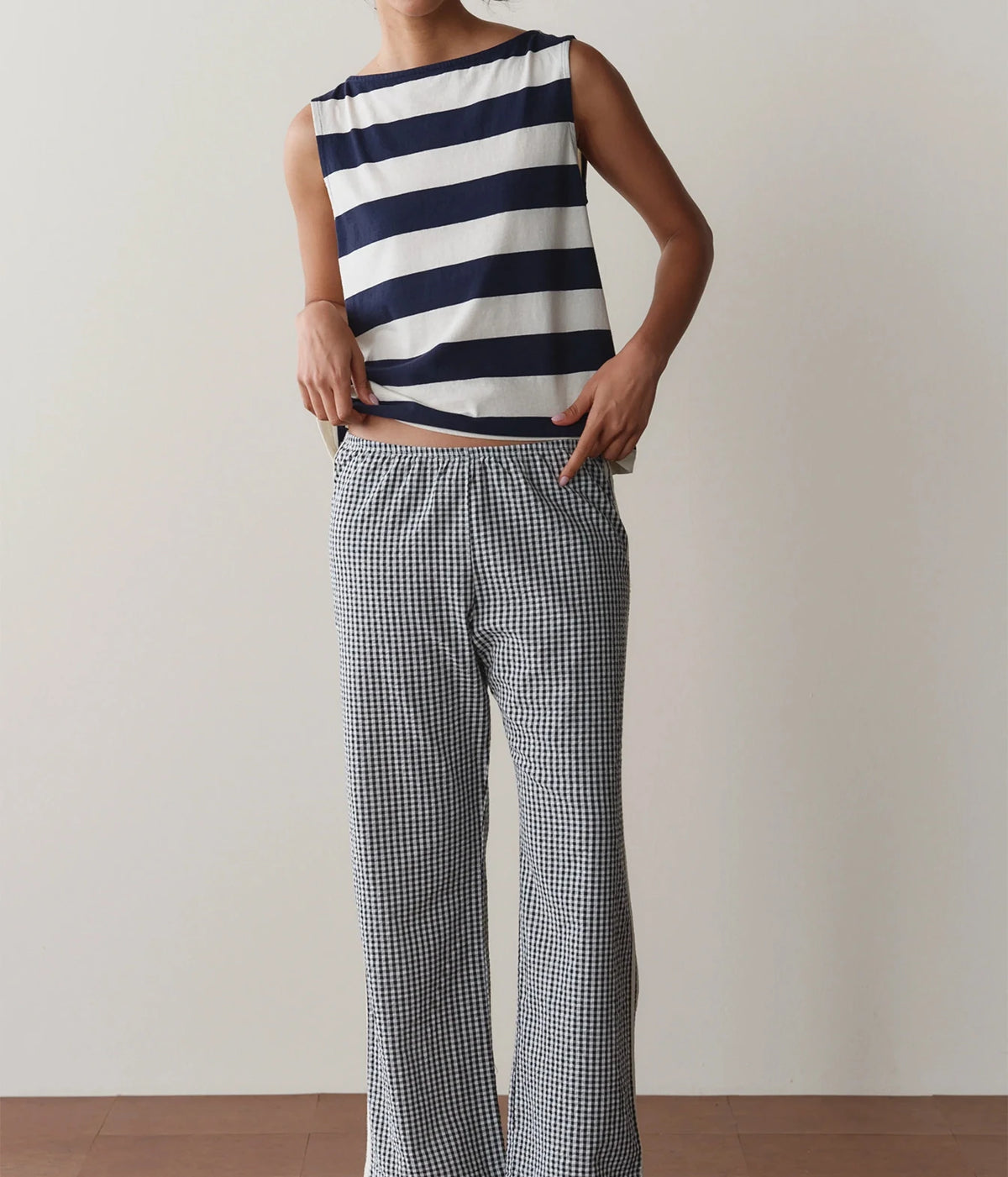 Model wearing navy gingham check pants with a striped tank top, front view showing the straight-leg silhouette.