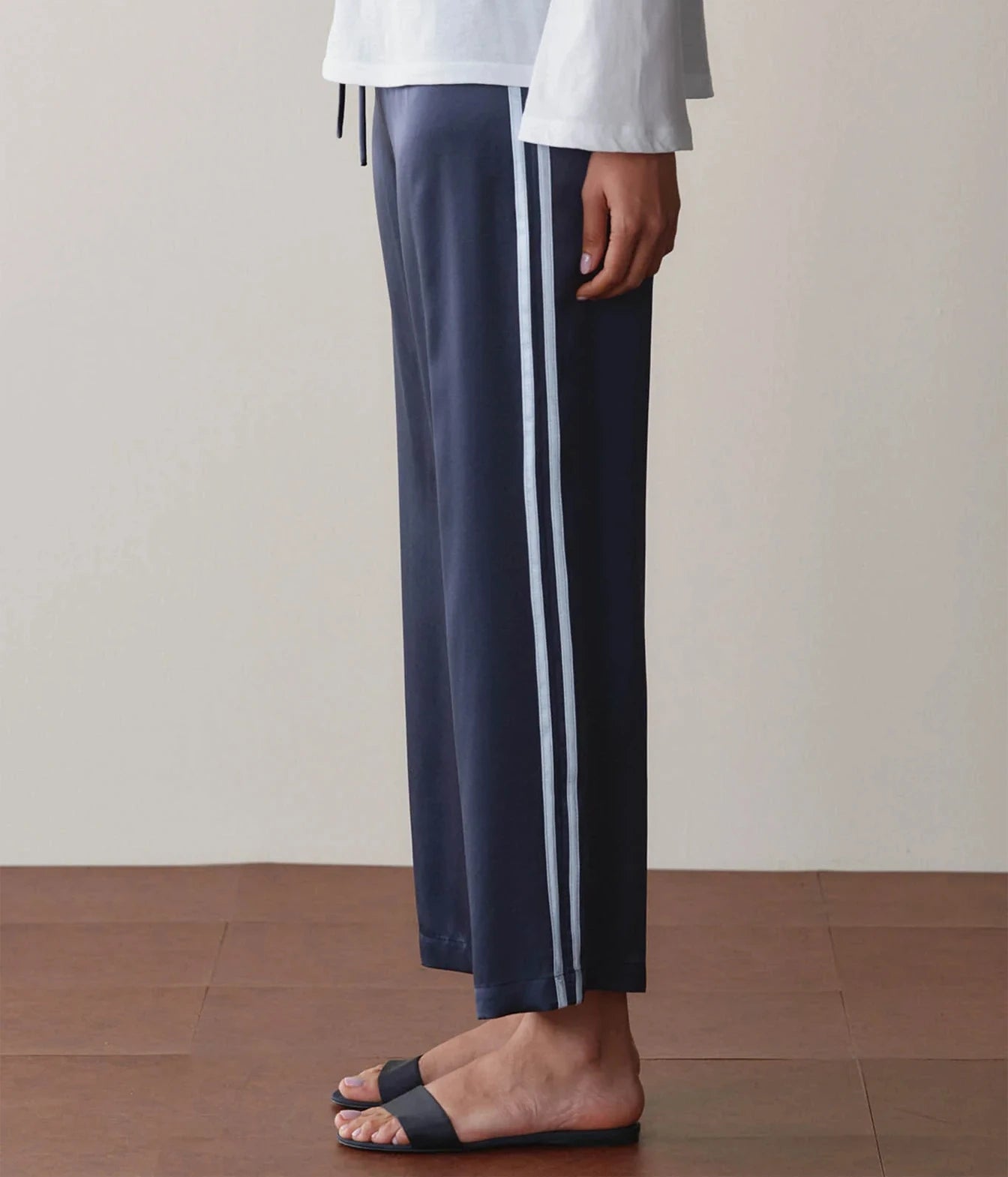 DONNI Silk Stripe Crop Pant in Navy Cloud, side view on model showing contrast stripe detail