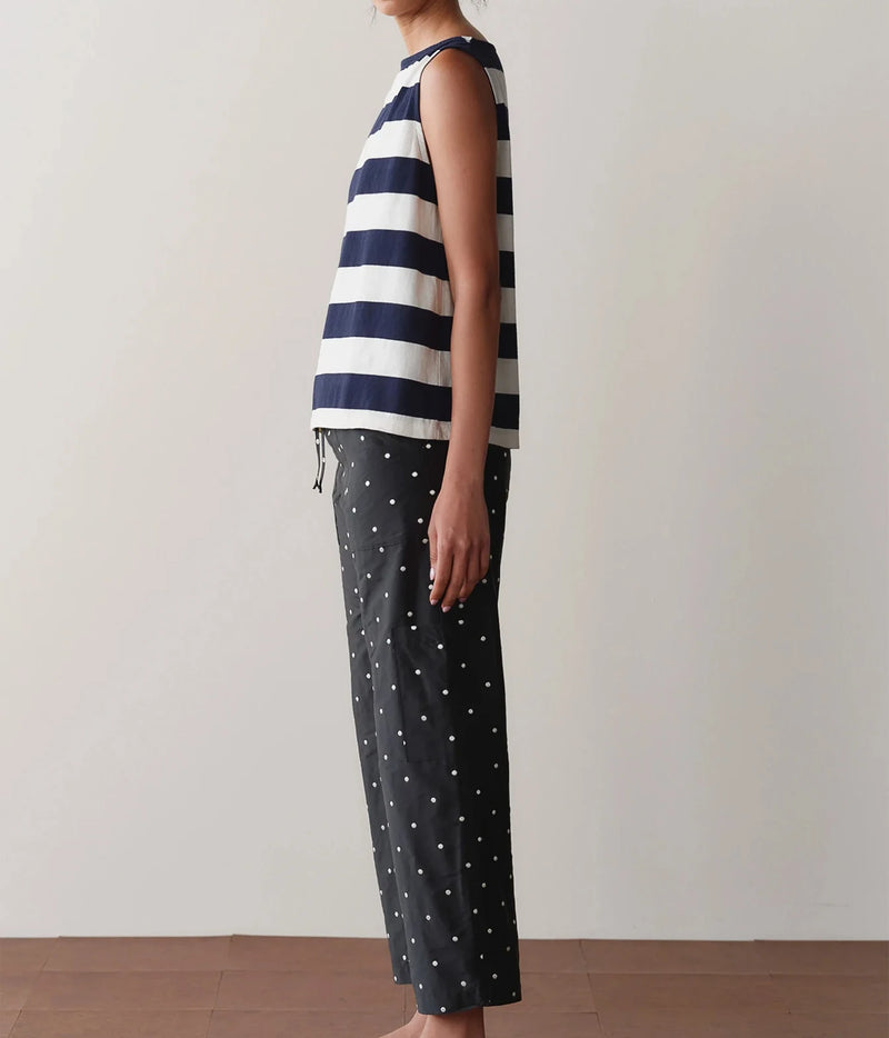 Model wearing black polka dot cargo pants with a striped tank top, shown from a side angle highlighting the side cargo pocket and straight-leg silhouette.