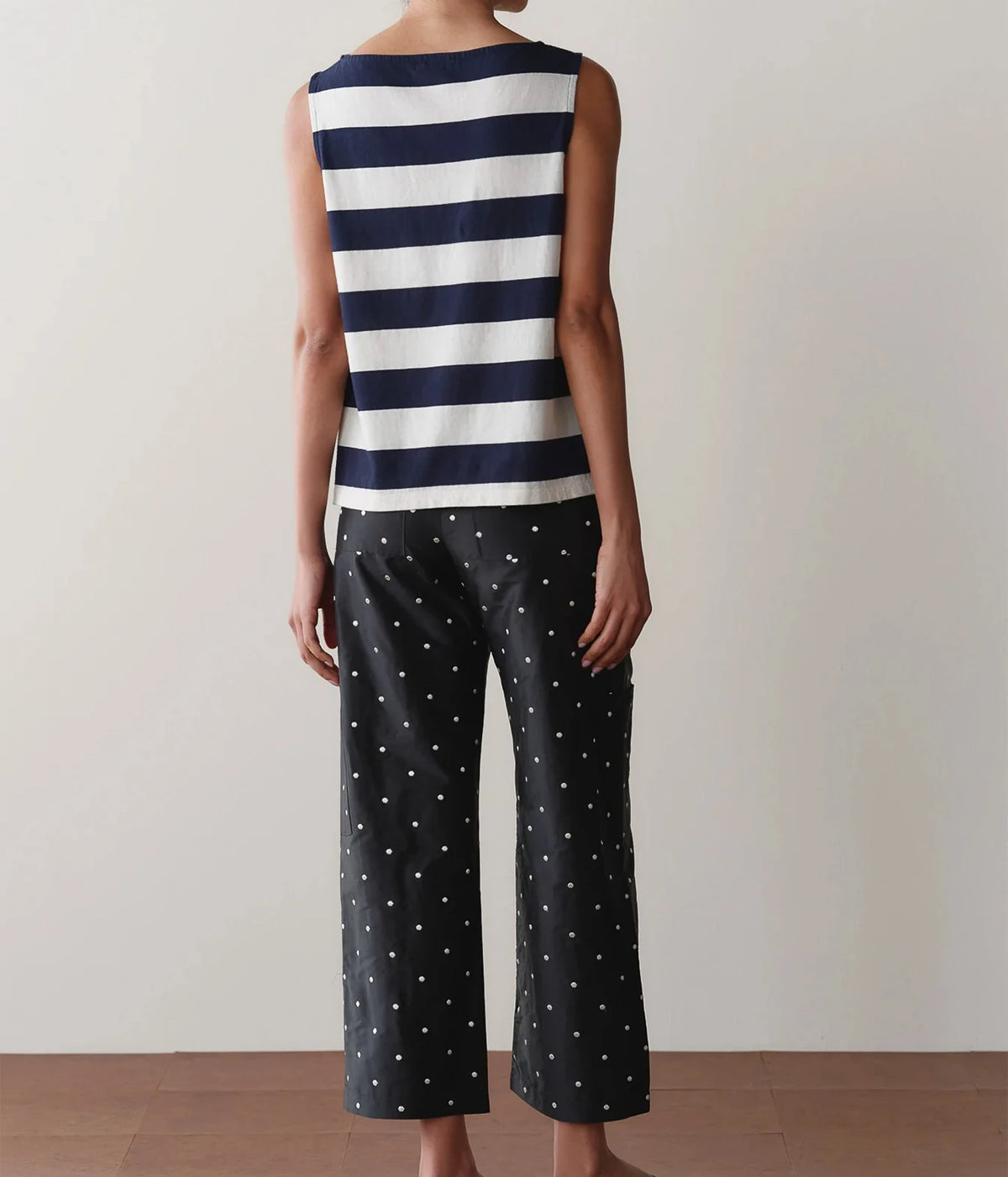 Model wearing black polka dot cargo pants with a striped tank top, front view showing the relaxed fit and drawstring waist detail.