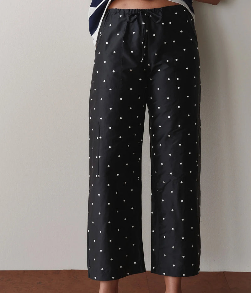 Model wearing black polka dot cargo pants, back view showing the relaxed straight-leg fit.