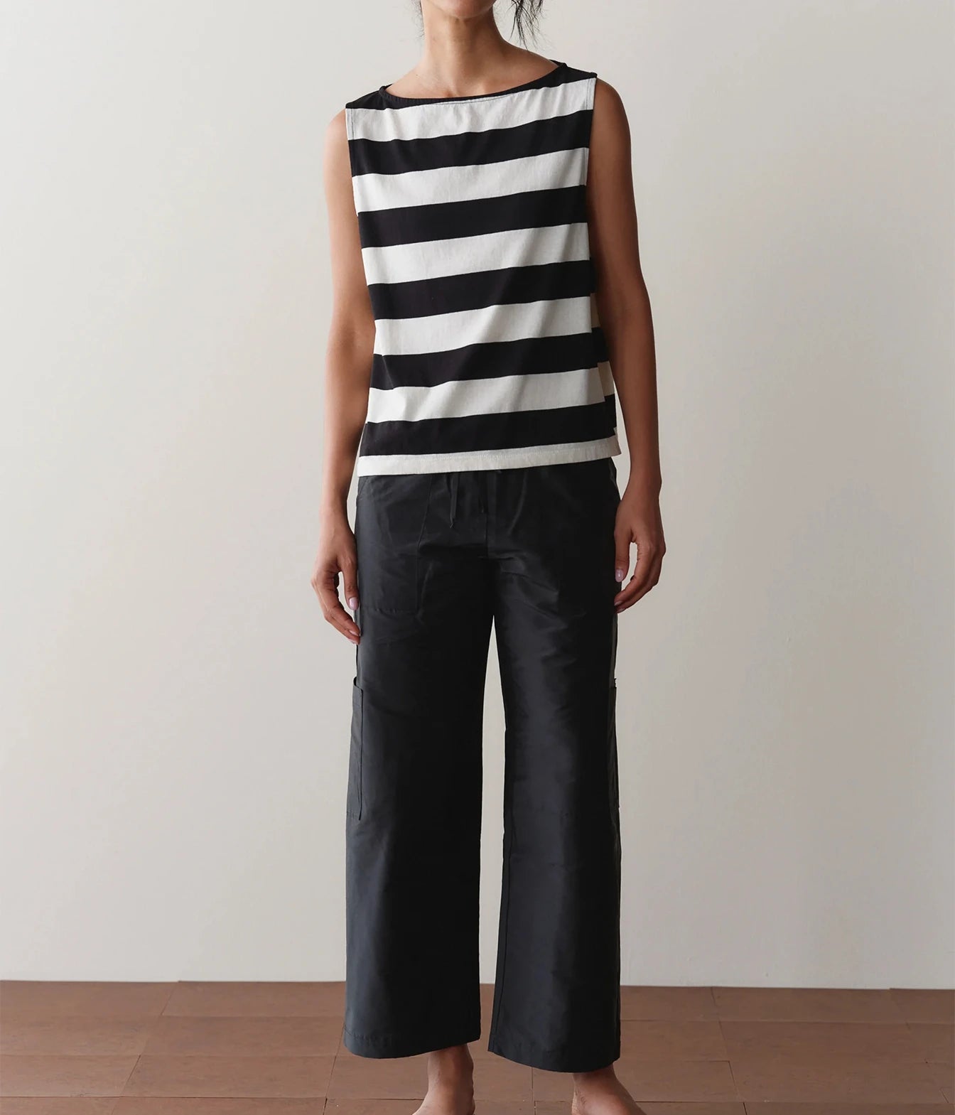 Model wearing black cargo pants with a striped tank top, front view showing the drawstring waist detail.