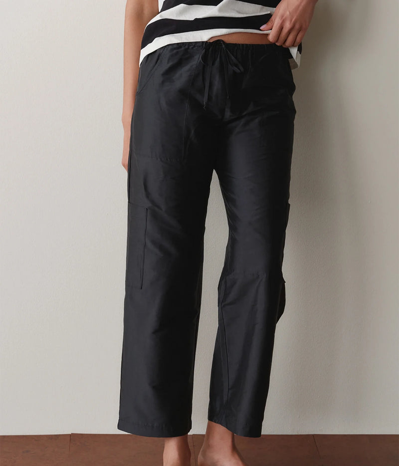 Close-up of black cargo pants showing the drawstring waist and side cargo pocket detail.