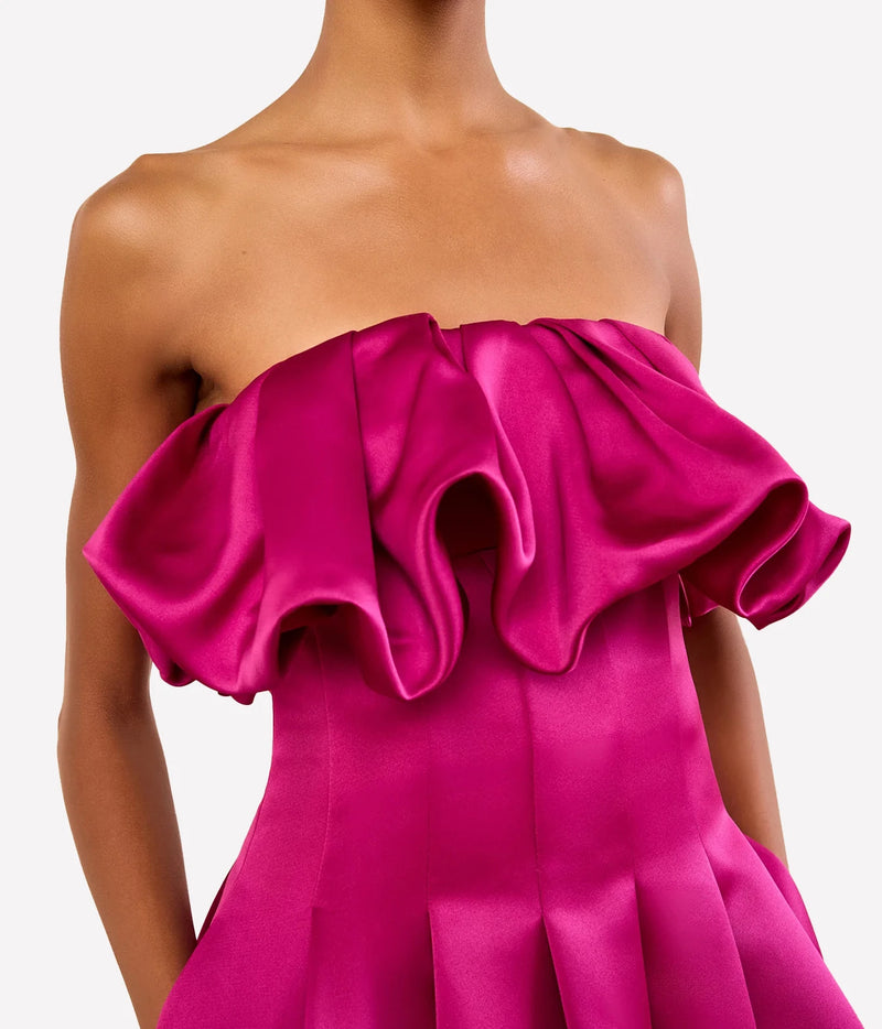 A close-up of a model wearing a strapless hot pink Ulla Johnson Cosima Strapless Satin Dress in Orchid