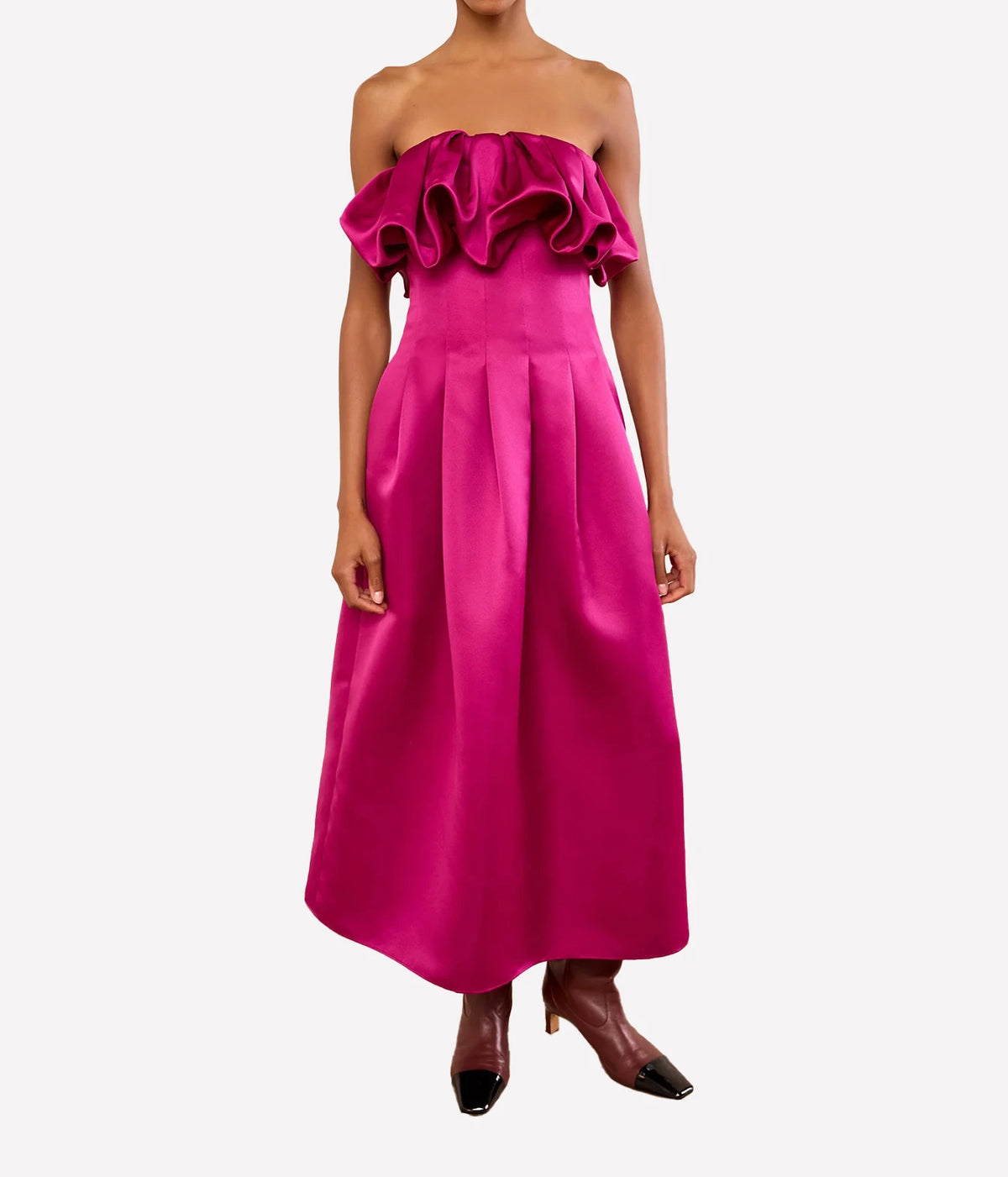 A model wearing a bright magenta pink off-the-shoulder midi dress with a ruffled neckline and a pleated skirt, Ulla Johnson Cosima Strapless Satin Dress in Orchid