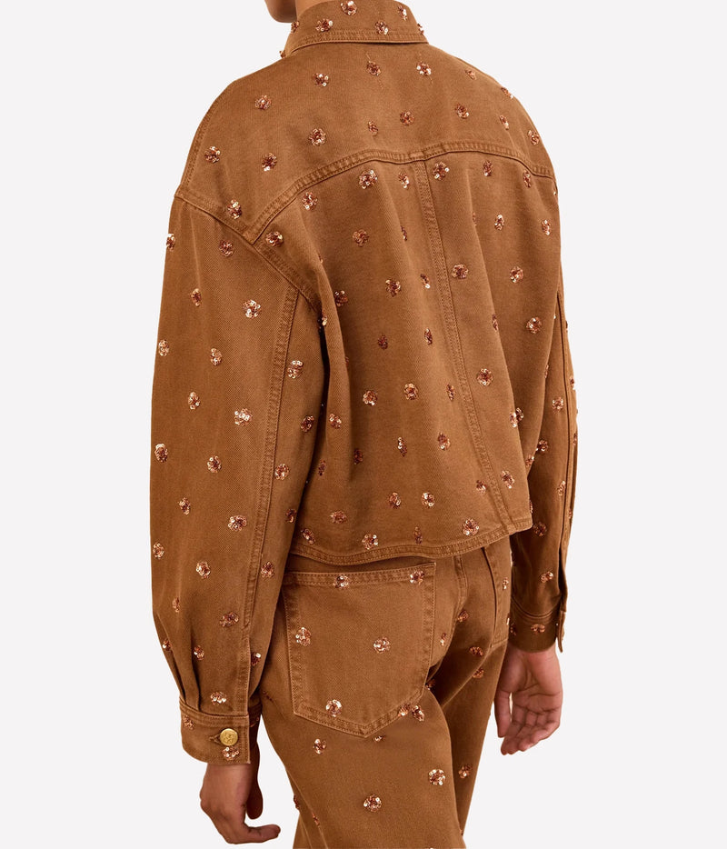 Model wearing Ulla Johnson The Bobbi Embellished Denim Jacket in Umber, back view