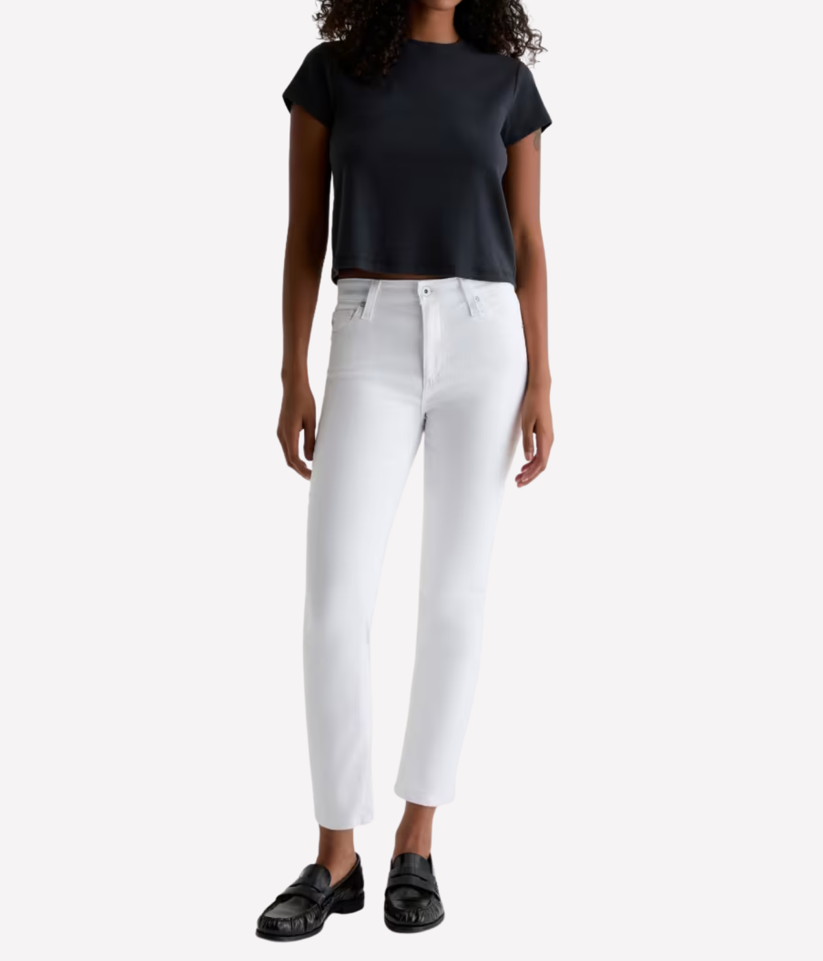 Person wearing a black top and white pants on a white background