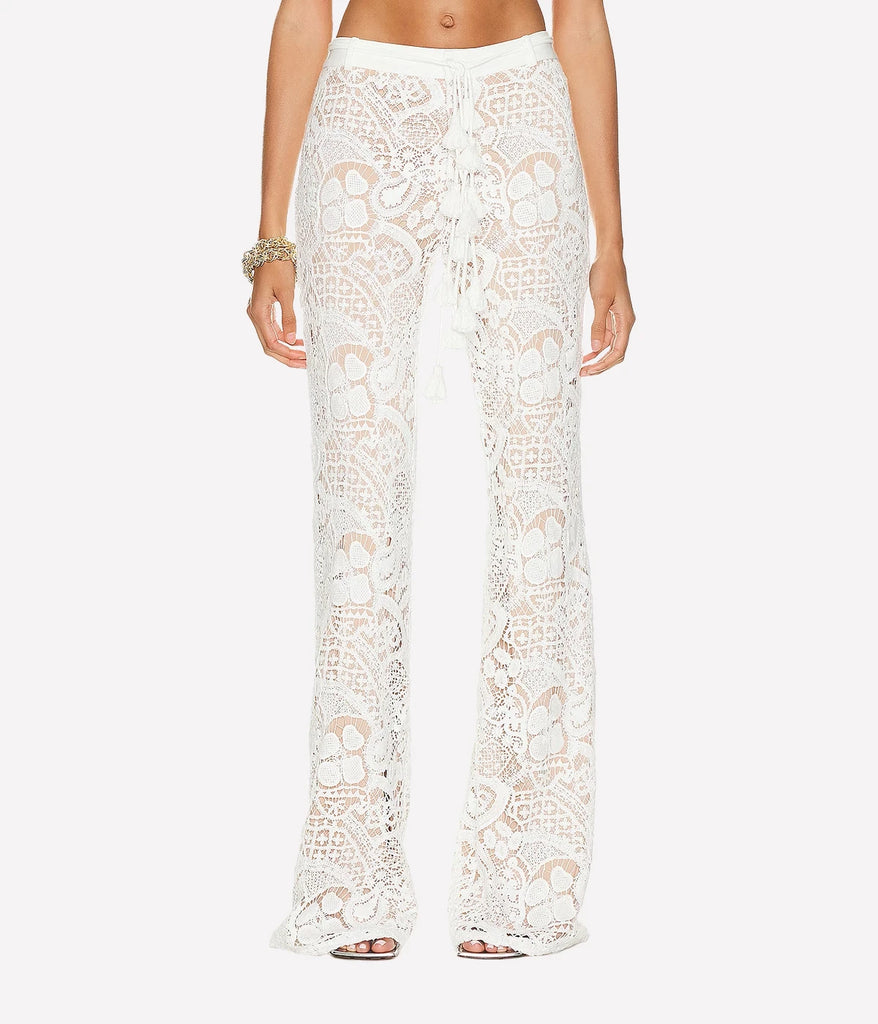 Image of a all over lace fabric wide leg pant in white, featuring a high waist, delicate lace fabric, tie waist belt, flare bottom and nude lining. Europe summer, summer outfit, festival outfit, made in miami, pull on pant, matching set. 