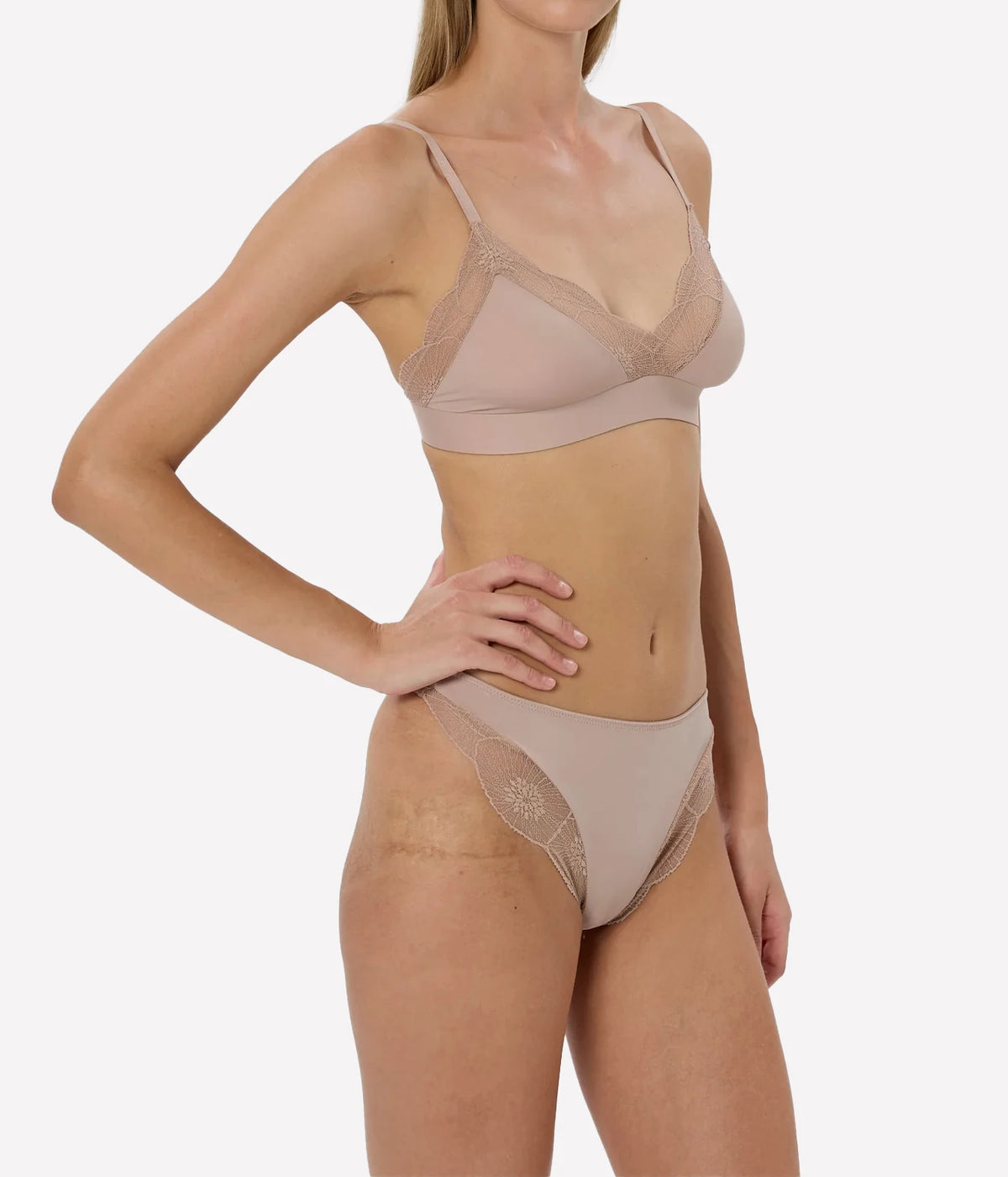 Model wearing the Anemone Thong in Nude with matching bra, angled front view.