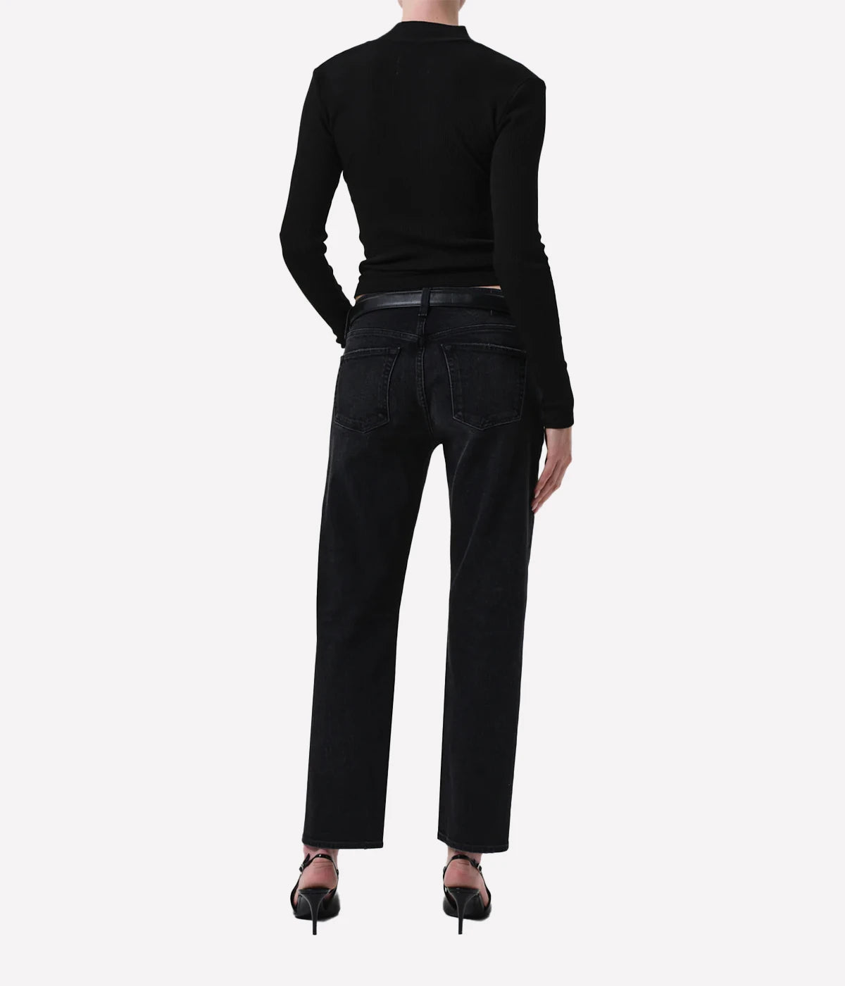 Person wearing black turtleneck and jeans on a white background