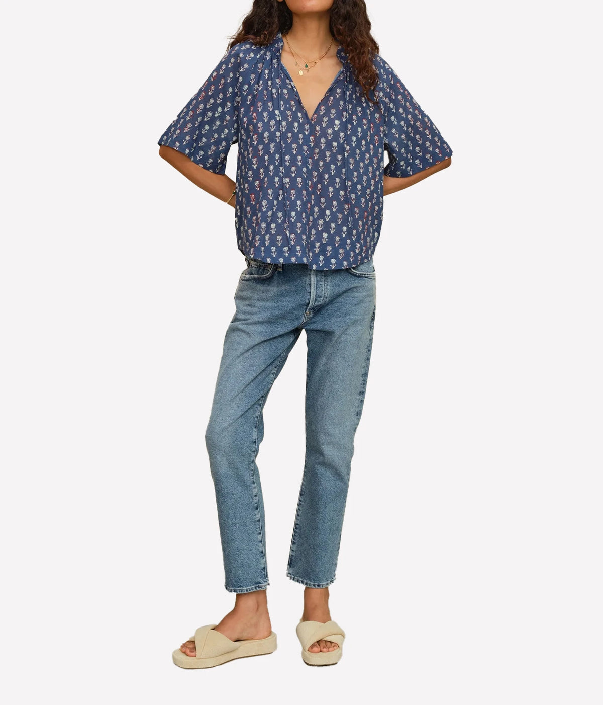 Woman wearing the M.A.B.E Ari print top in Indigo with light blue jeans and sandals, full-length front view.