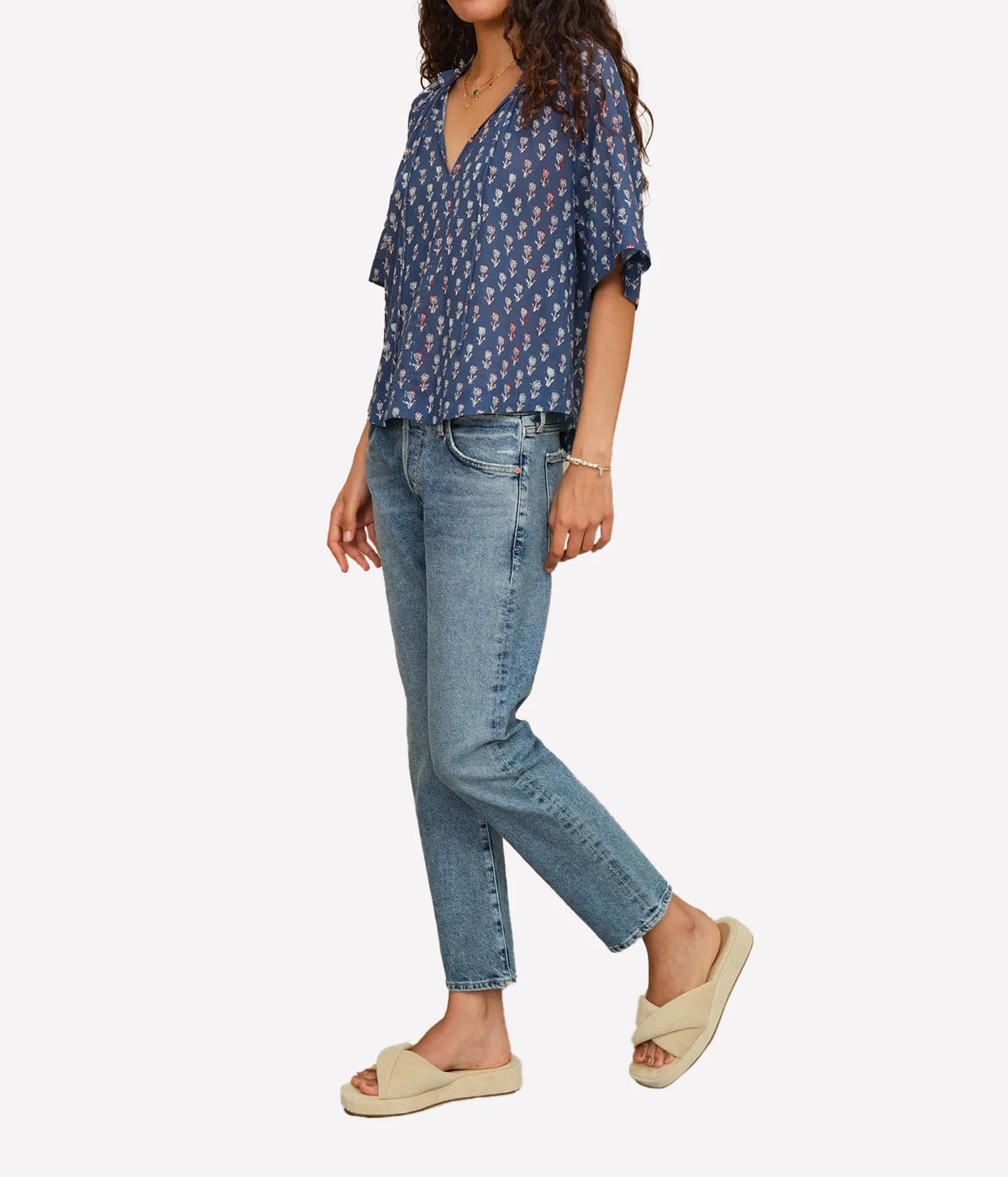 Angled front view of the M.A.B.E Ari print top in Indigo, worn with light blue jeans and sandals.