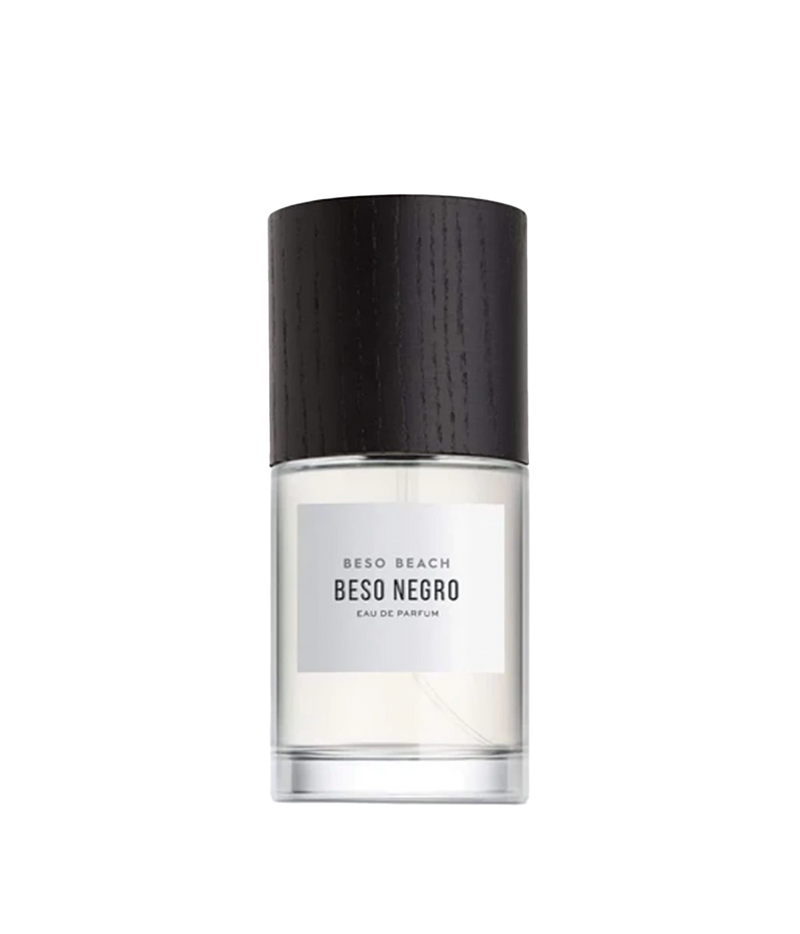 A bottle of Beso Beach Beso Negro Eau de Parfum with a textured black cap and a minimalist white label, shown on a solid white background.