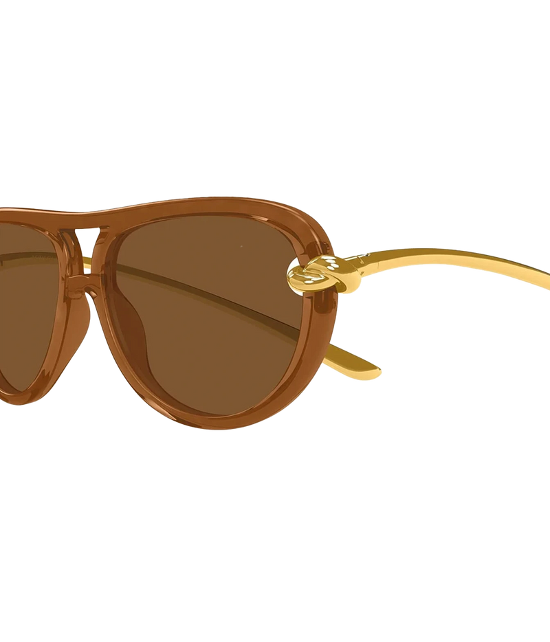 Close-up of Bottega Veneta Knot Aviator Sunglasses in Brown showing the brown lens and gold-tone knot hinge detail