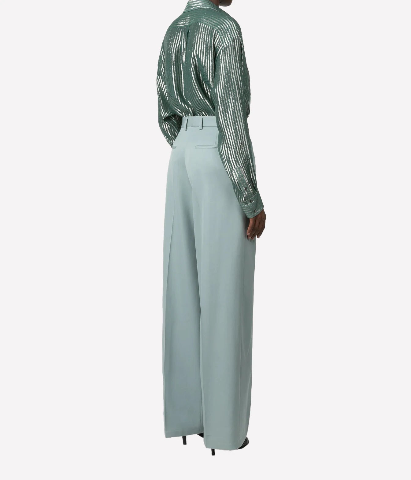 A model shown from the back wearing a sage green sequined long-sleeve shirt and light sage green wide-leg trousers, set against a plain light gray background.