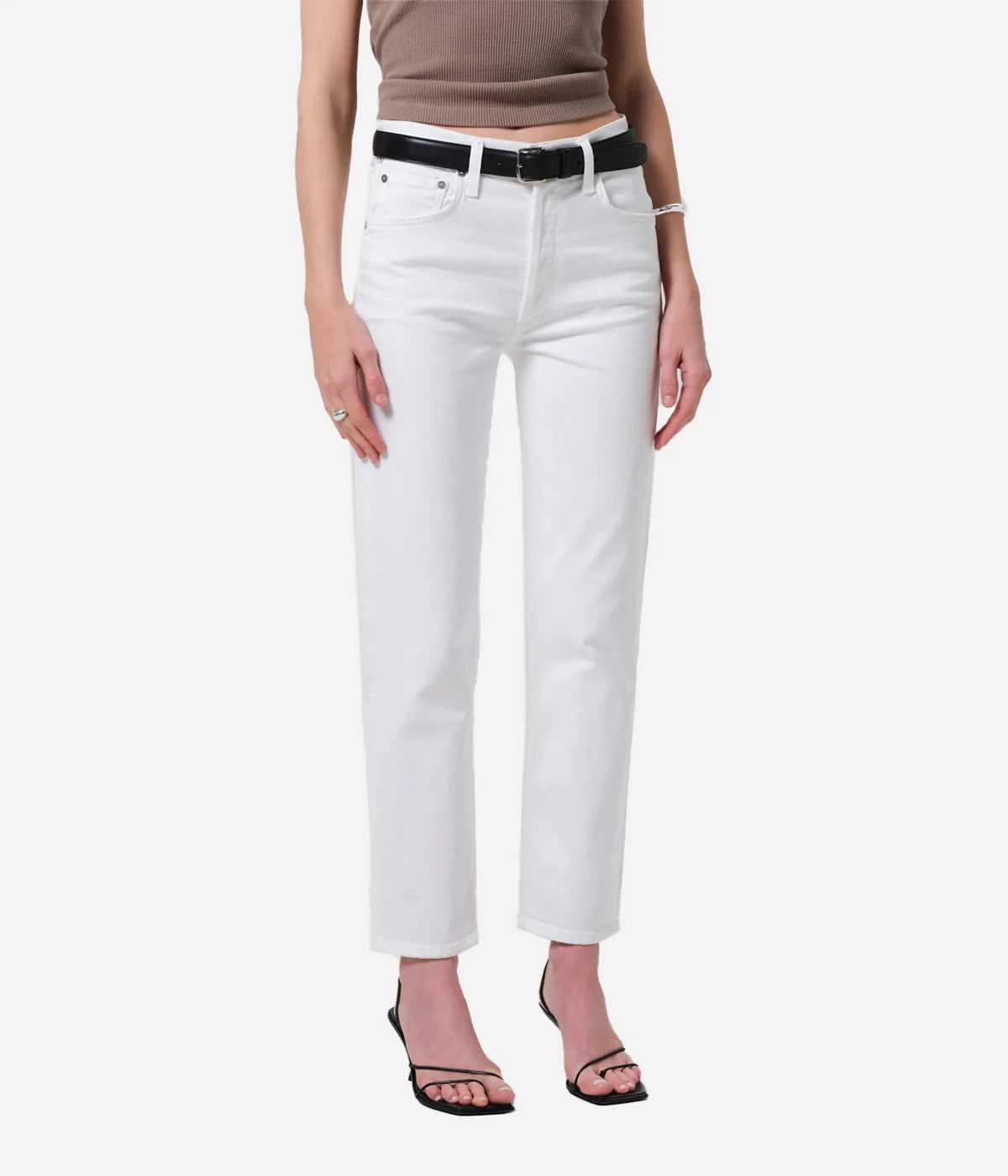 Person wearing white jeans with a black belt on a white background