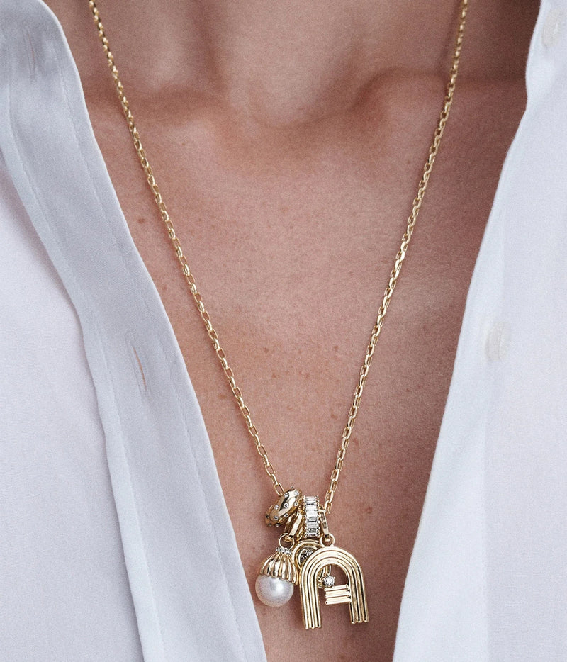 Model in an open white shirt wearing the Adina Reyter Diamond Polka Dot Big Bead in 14K Yellow Gold with a cluster of gold charms on a long chain