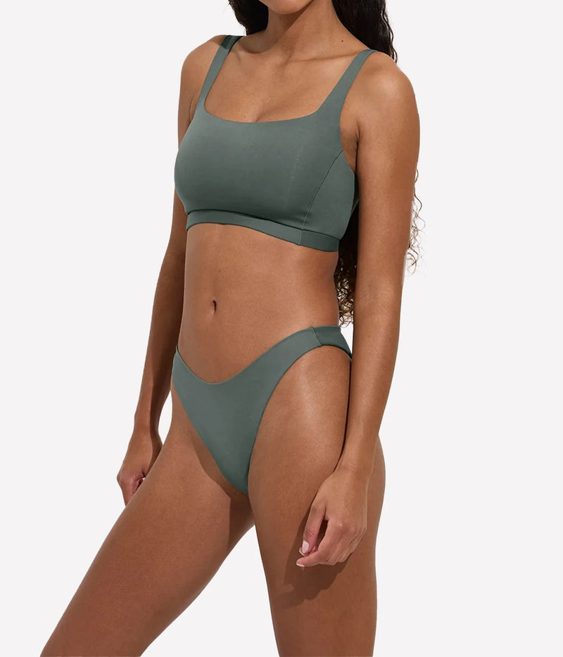 Model wearing the Dip Bottom in Agave with matching green swim top, angled front view.