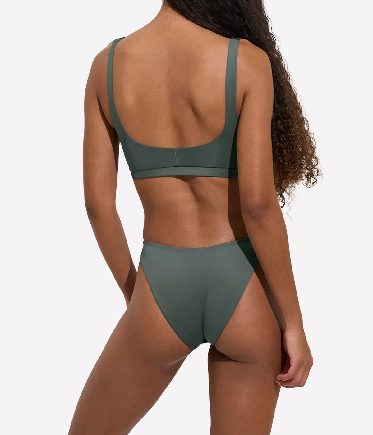 Model wearing the Dip Bottom in Agave with matching green swim top, back view.