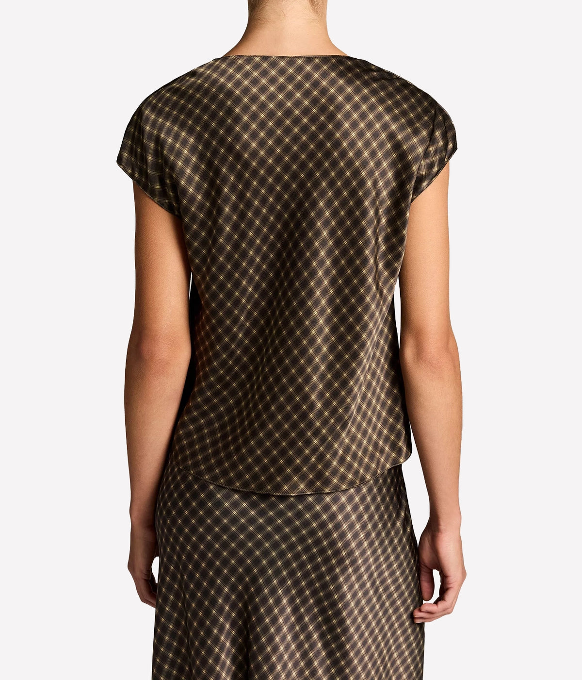 Back view of a model wearing the Vince Ombre Plaid Blouse In Black Camel untucked over the matching plaid midi skirt
