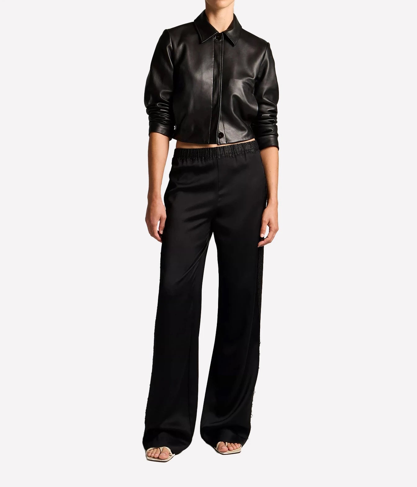 A model wearing a black leather cropped button-up shirt