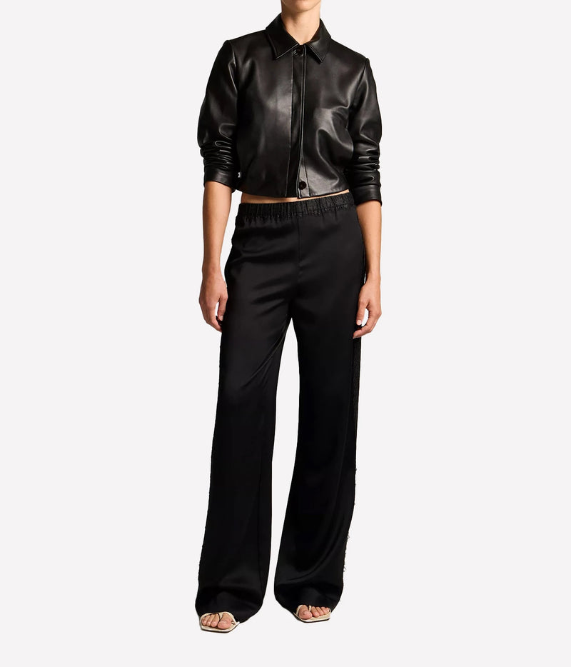 A model wearing a black leather cropped button-up shirt