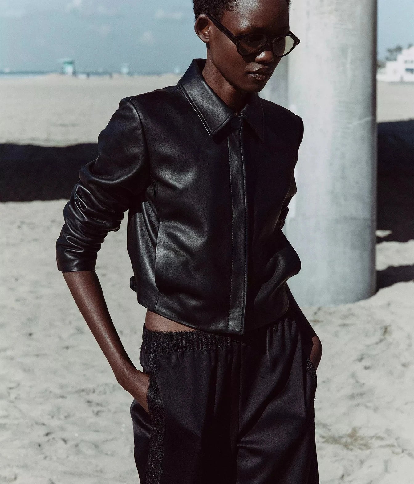A model wearing a black leather jacket and matching black pants