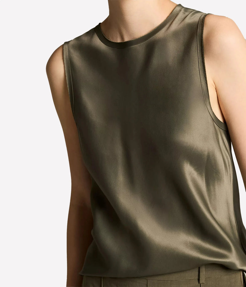A close-up of a model wearing a sleeveless satin top in a muted olive green color