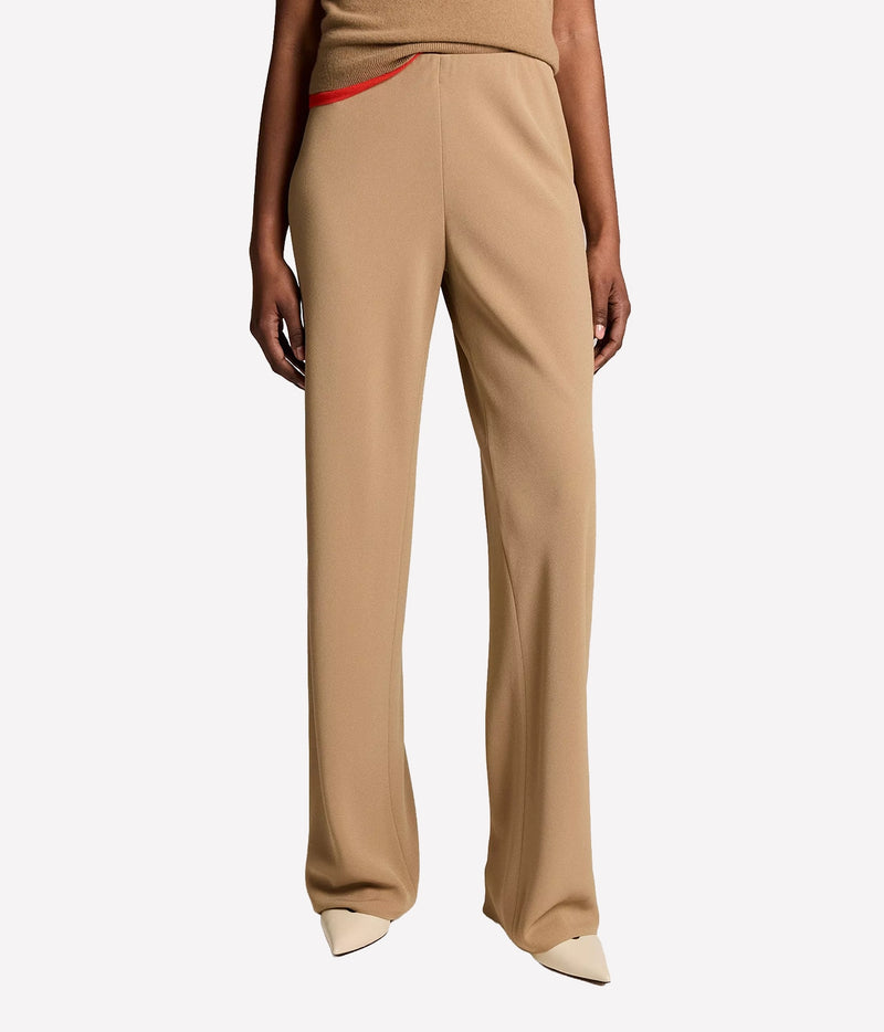 Front view of a model wearing the Vince Colette High Waist Pant In Carmello with a matching top with red trim and cream pointed flats, showing the high waist and wide leg
