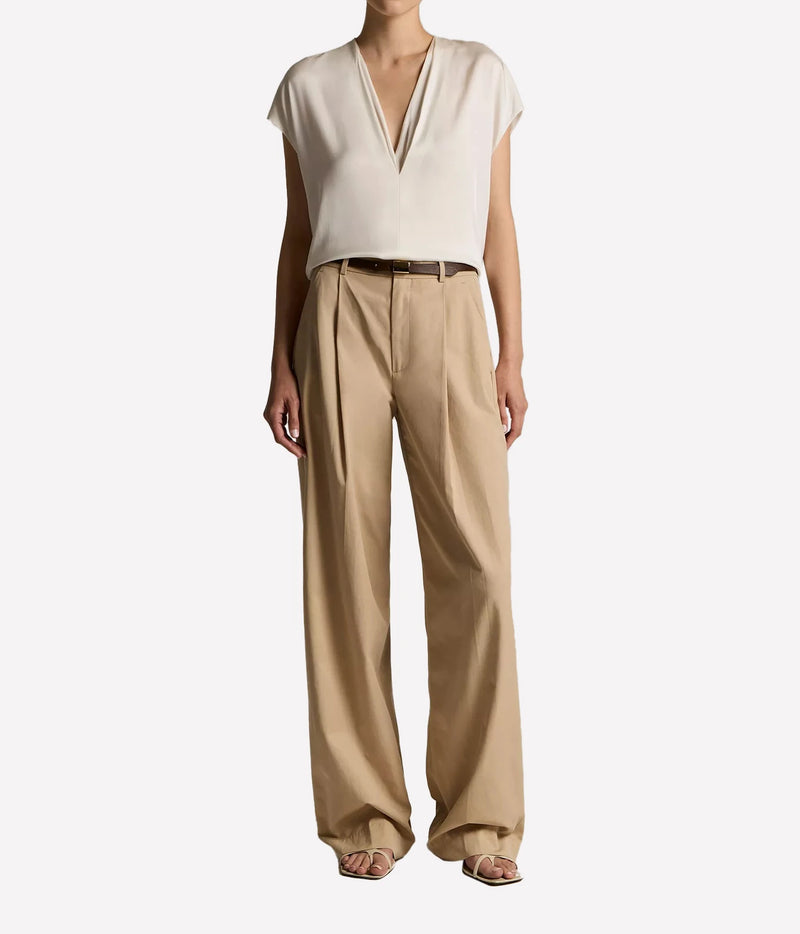 A model wearing a cream-colored short-sleeve V-neck top