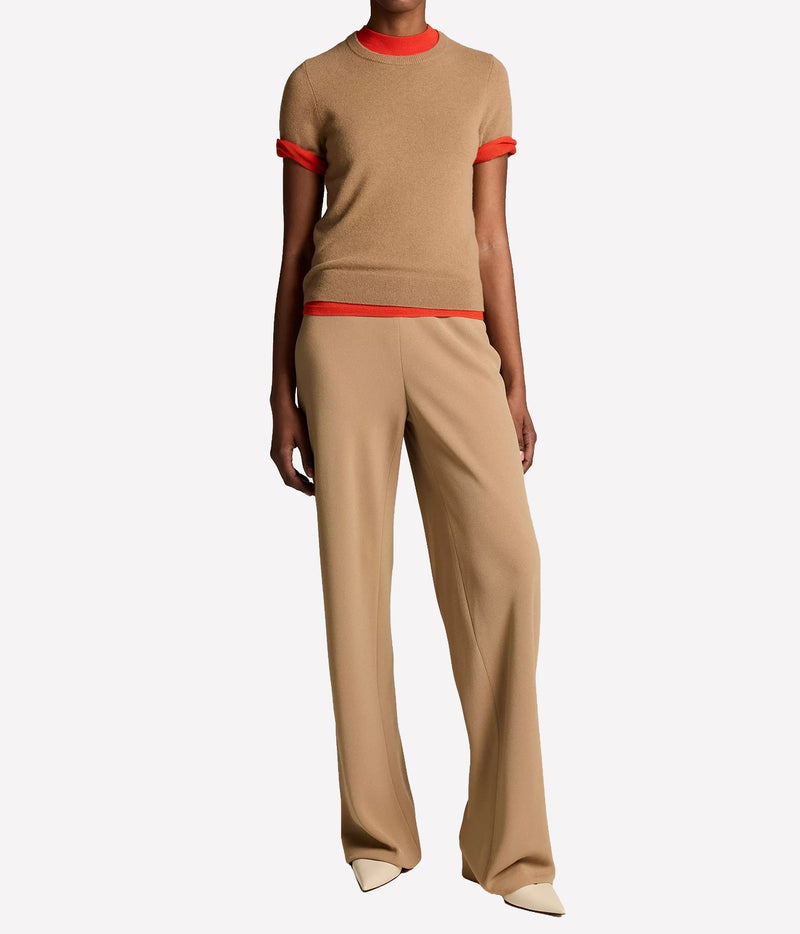 Full-length front view of a model wearing the Vince Colette High Waist Pant In Carmello with a matching short-sleeve top with red trim and cream pointed flats
