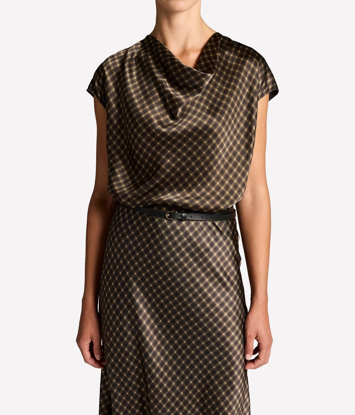Front view of a model wearing the Vince Ombre Plaid Blouse In Black Camel tucked into the matching plaid skirt with a thin black belt, showing the draped cowl neckline and cap sleeves