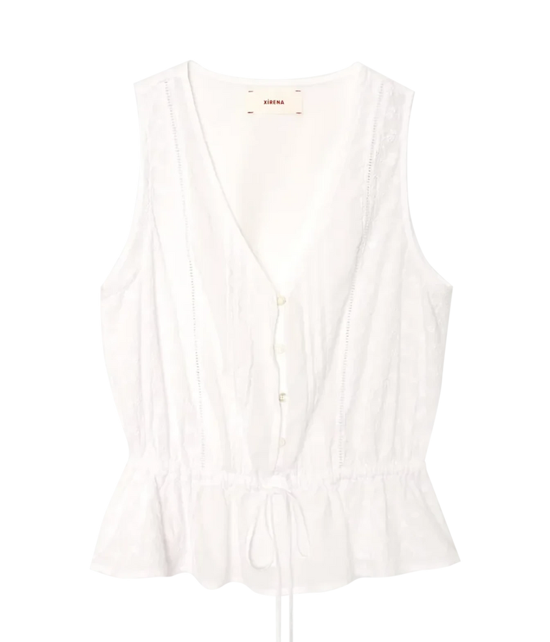 Xirena Emma Top in Blanc laid flat, showing the V-neckline, partial button front, lace inset panels and tie drawstring waist above the ruffled peplum hem