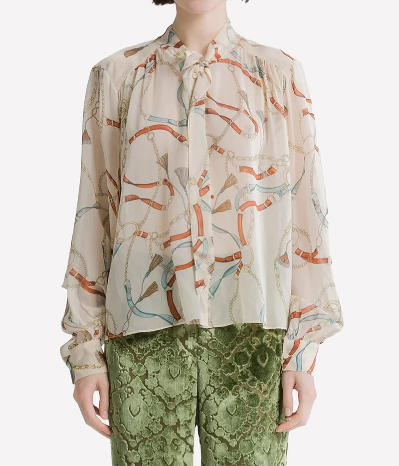 Woman wearing the Forte Forte crown print silk shirt in Ivory with green trousers, front view.