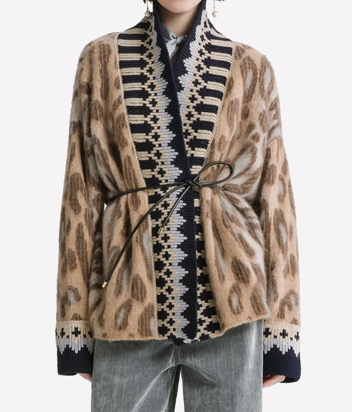 Woman wearing the Forte Forte Brit Leopard alpaca cardigan in Gold, belted at the waist with light jeans, front view.