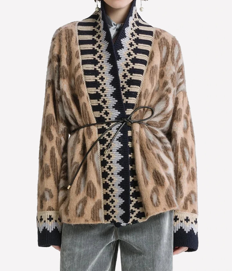 Woman wearing the Forte Forte Brit Leopard alpaca cardigan in Gold, belted at the waist with light jeans, front view.