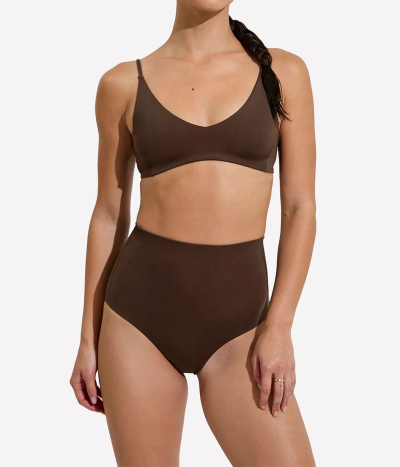 A woman modeling a two-piece bikini set in a solid dark brown color, featuring a scoop-neck top and high-waisted bottoms, Hi Tide Bottom In Cold Brew