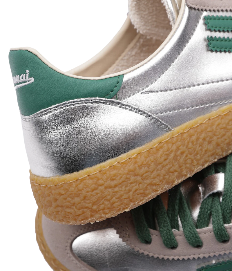 Close-up of the Puraai 6.01 XS Sneaker in Jade, showing the green heel tab with logo, metallic silver vegan leather and textured gum sole
