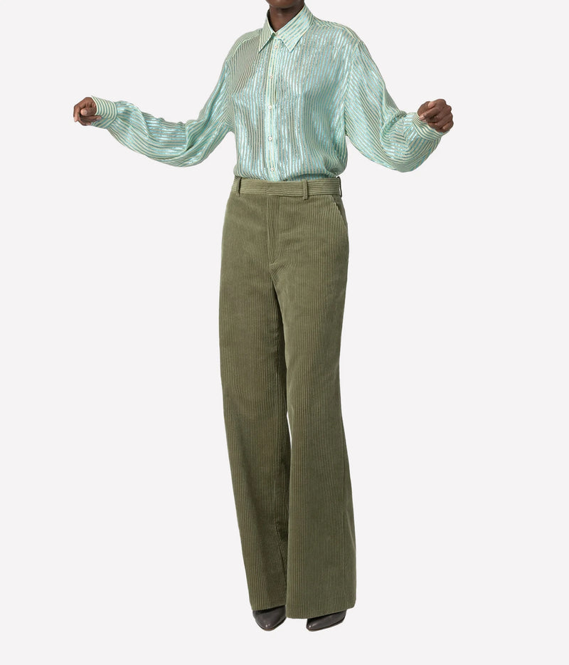 A model wearing a mint green striped long-sleeve button-up shirt and olive green wide-leg trousers, shown from the neck down against a light gray background.