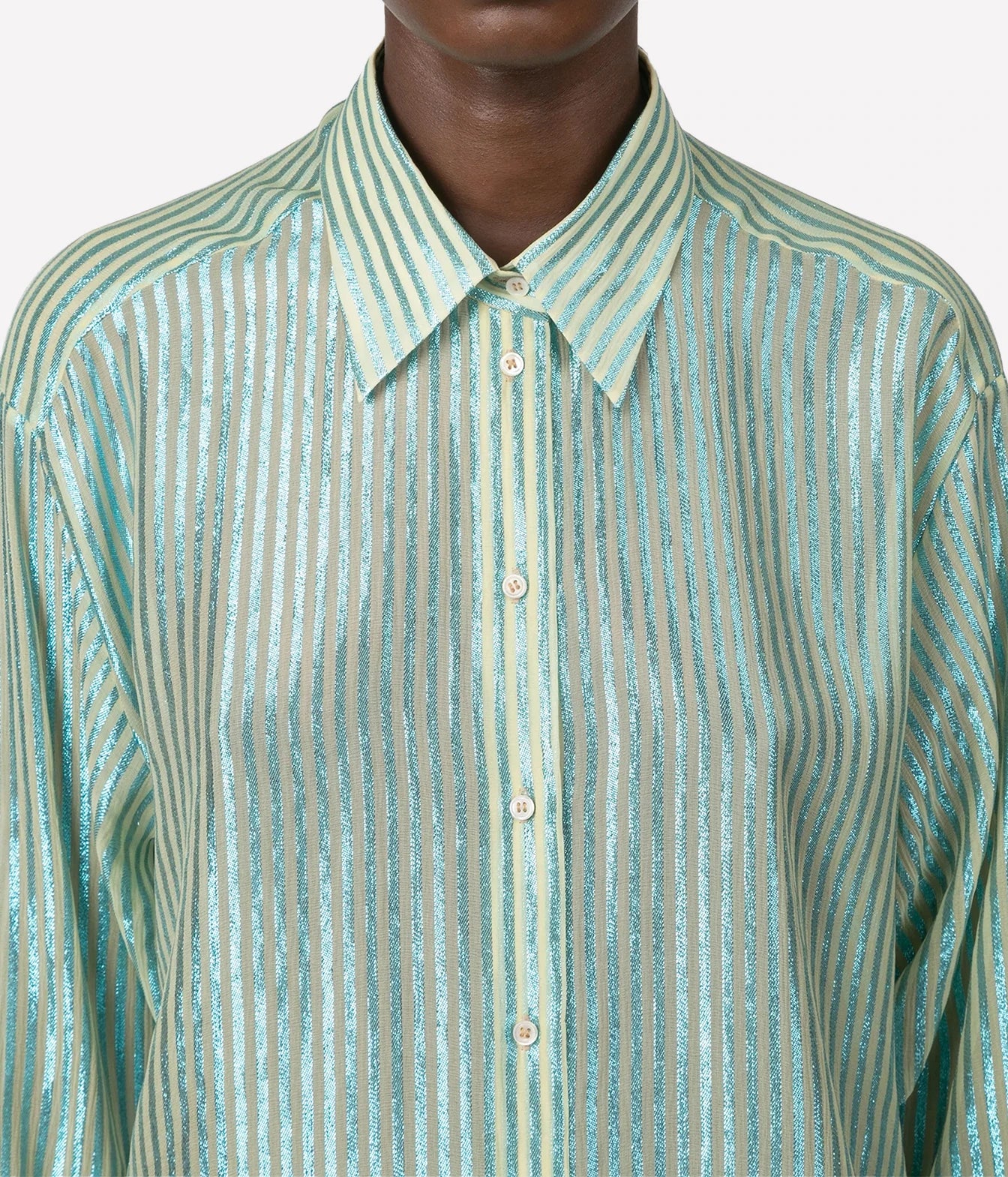 A close-up of a long-sleeve button-up shirt with a pointed collar, featuring vertical metallic stripes in a light mint green and silver colorway.