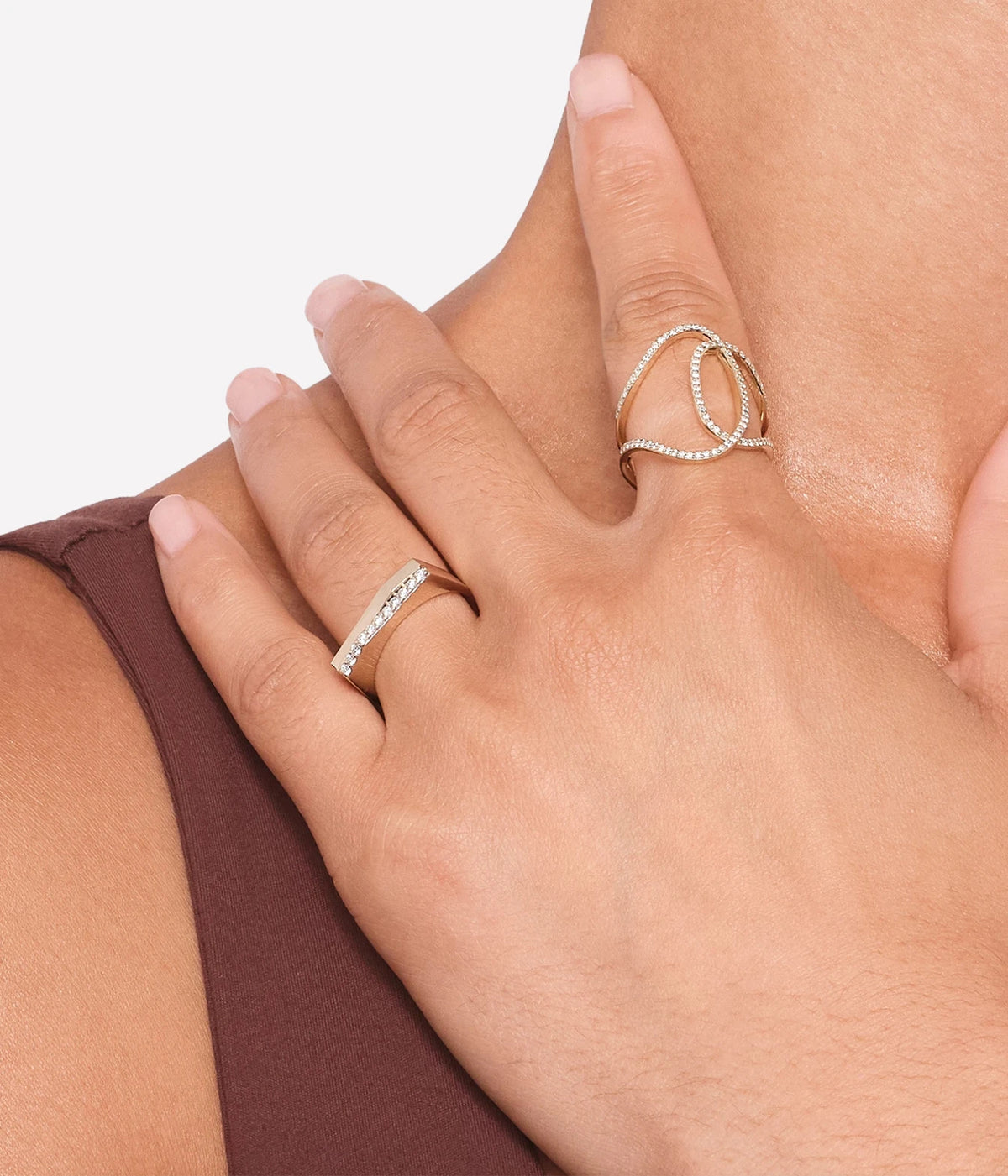 Close-up of a model's hands wearing the LANA Diamond Thin Sculpted Ring in Yellow Gold, showing the open curved wrap shape on the finger with a burgundy top