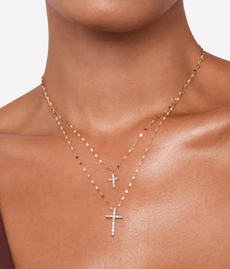 Model wearing the LANA Baguette Cut Diamond Mini Cross Pendant Necklace in Yellow Gold as the shorter upper strand, layered with a longer baguette diamond cross pendant