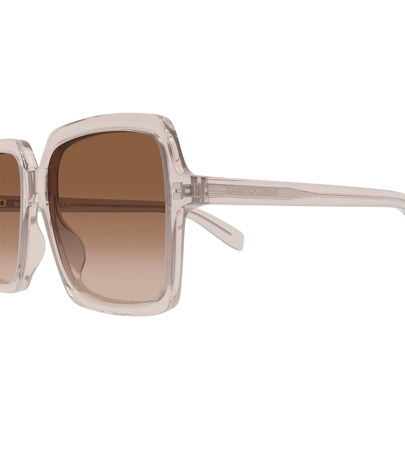 Close-up side view of Saint Laurent large square sunglasses with a transparent nude frame and brown gradient lenses.