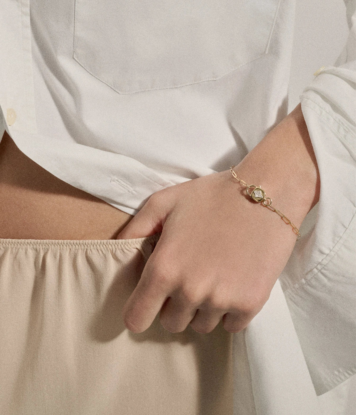 Model wearing the Pascale Monvoisin Louise Bracelet with a white long-sleeve top and cream trousers, hand resting at the hip