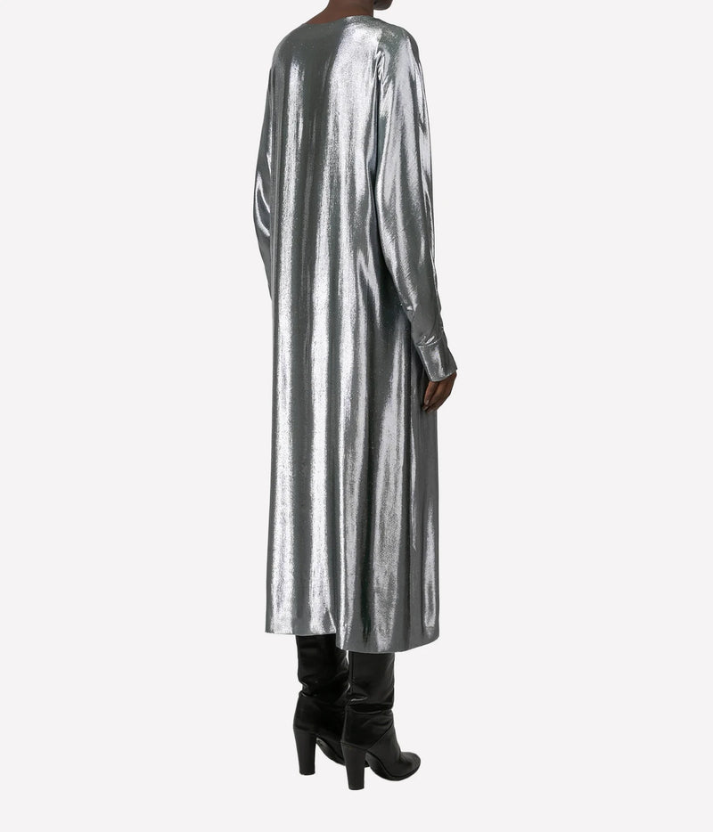 A model shown from the back wearing a long-sleeved, metallic silver midi dress with black knee-high boots, set against a plain light gray background.
