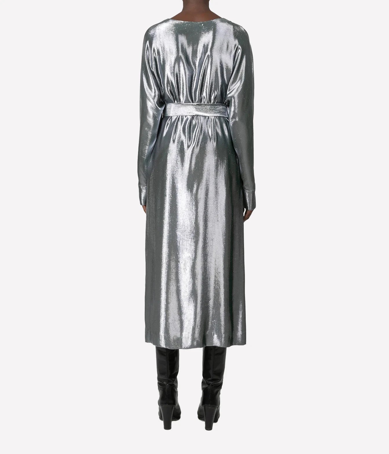 A model viewed from the back wearing a long-sleeved metallic silver midi dress with a matching waist belt, paired with black knee-high boots, against a light gray background.