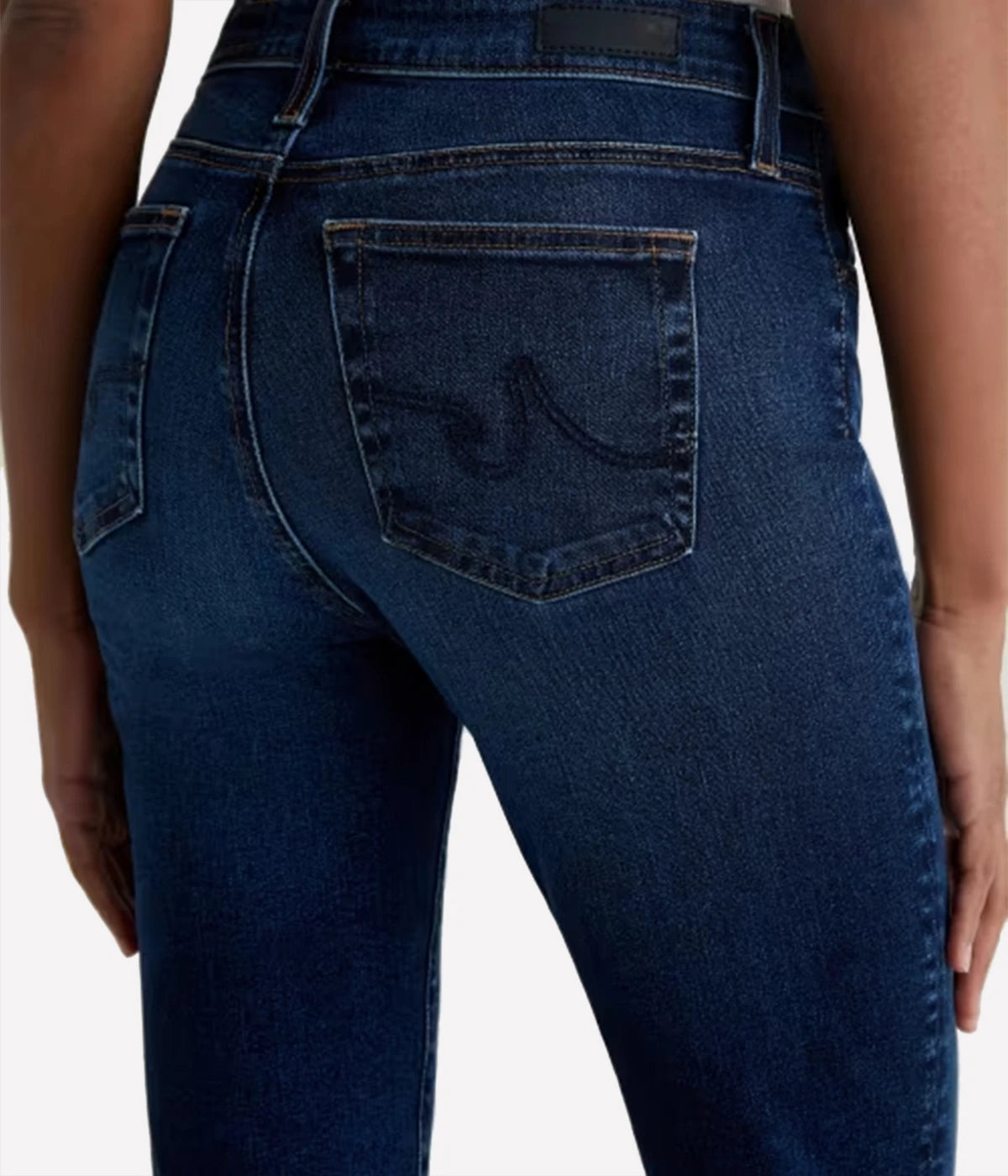 Blue jeans worn by a person on a light gray background